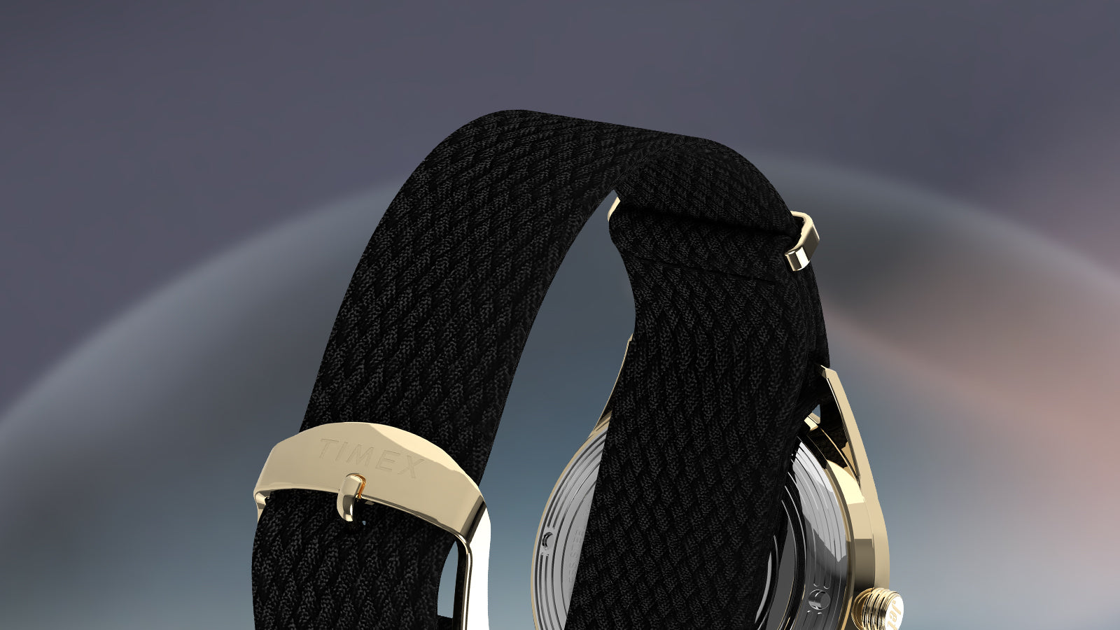 Rear view of the Timex Marlin® Jet Automatic’s black woven strap with gold-tone clasp engraved with “TIMEX,” attached to the gold-tone watch case.