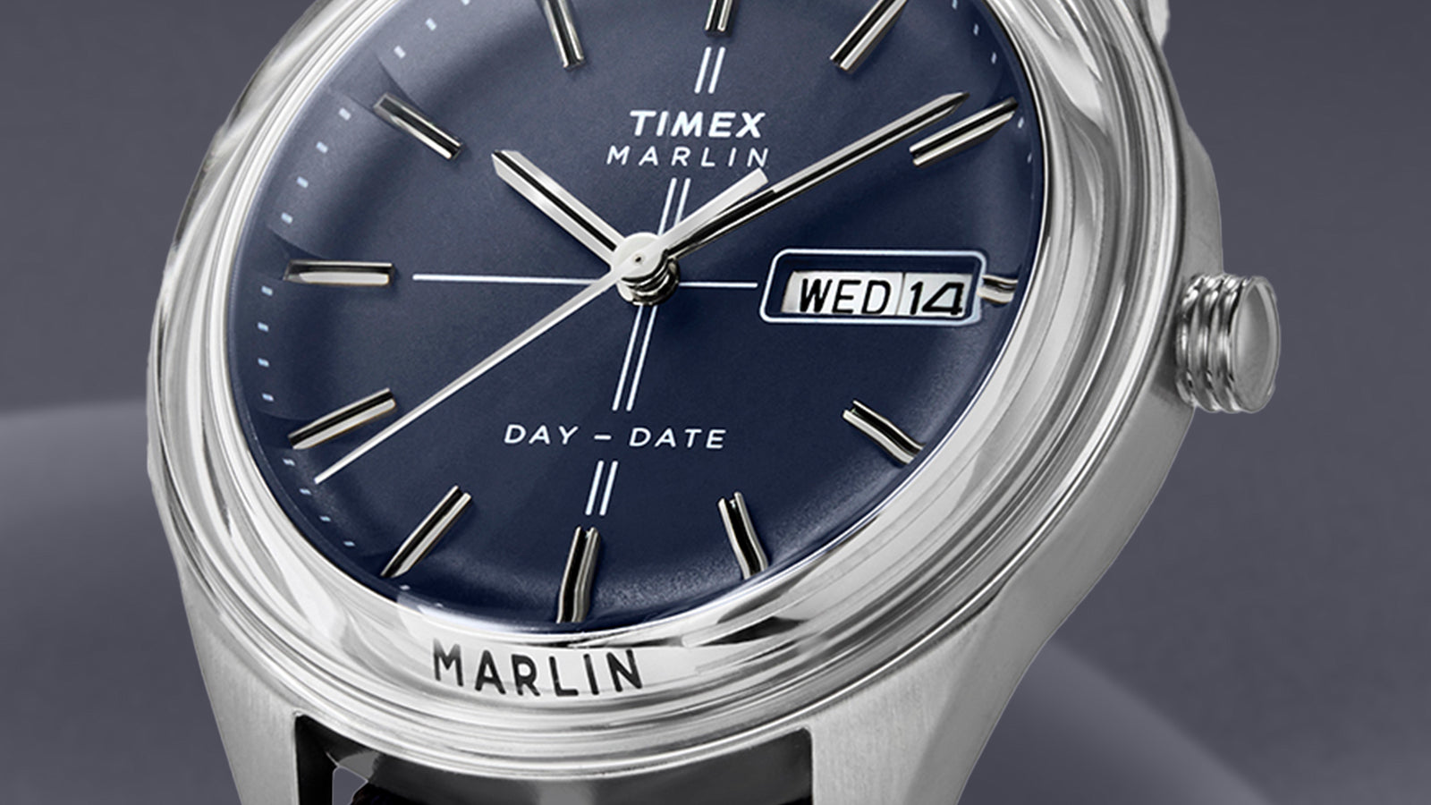 Close-up of the Timex Marlin® Jet Quartz dial with blue finish, silver-tone indices, and day-date window showing “WED 14.”
