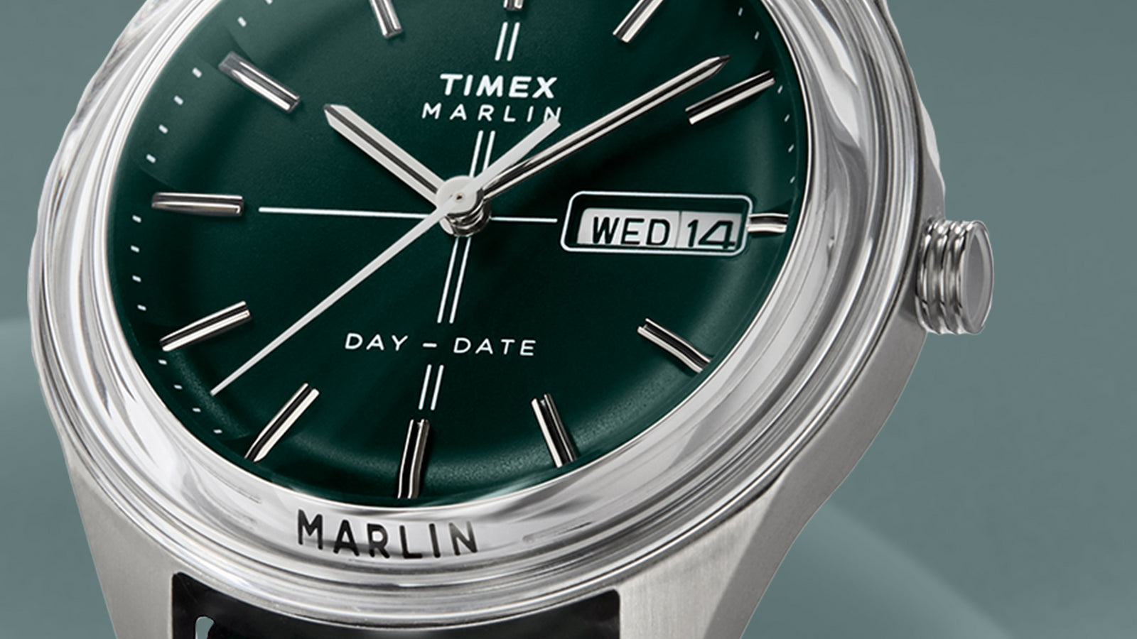 Close-up of the Timex Marlin® Jet Quartz dial in green, featuring silver-tone indices, slim hands, and day-date window showing “WED 14.”