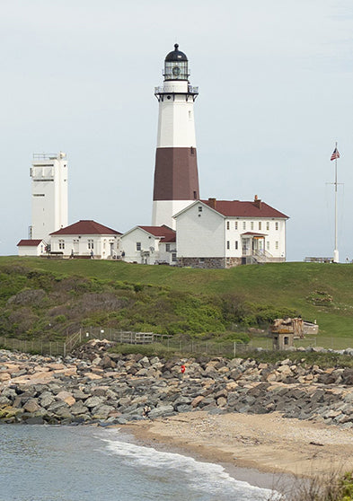 Montauk Point Lighthouse on Long Island, New York, overlooking the rocky shoreline with the ocean in the background.