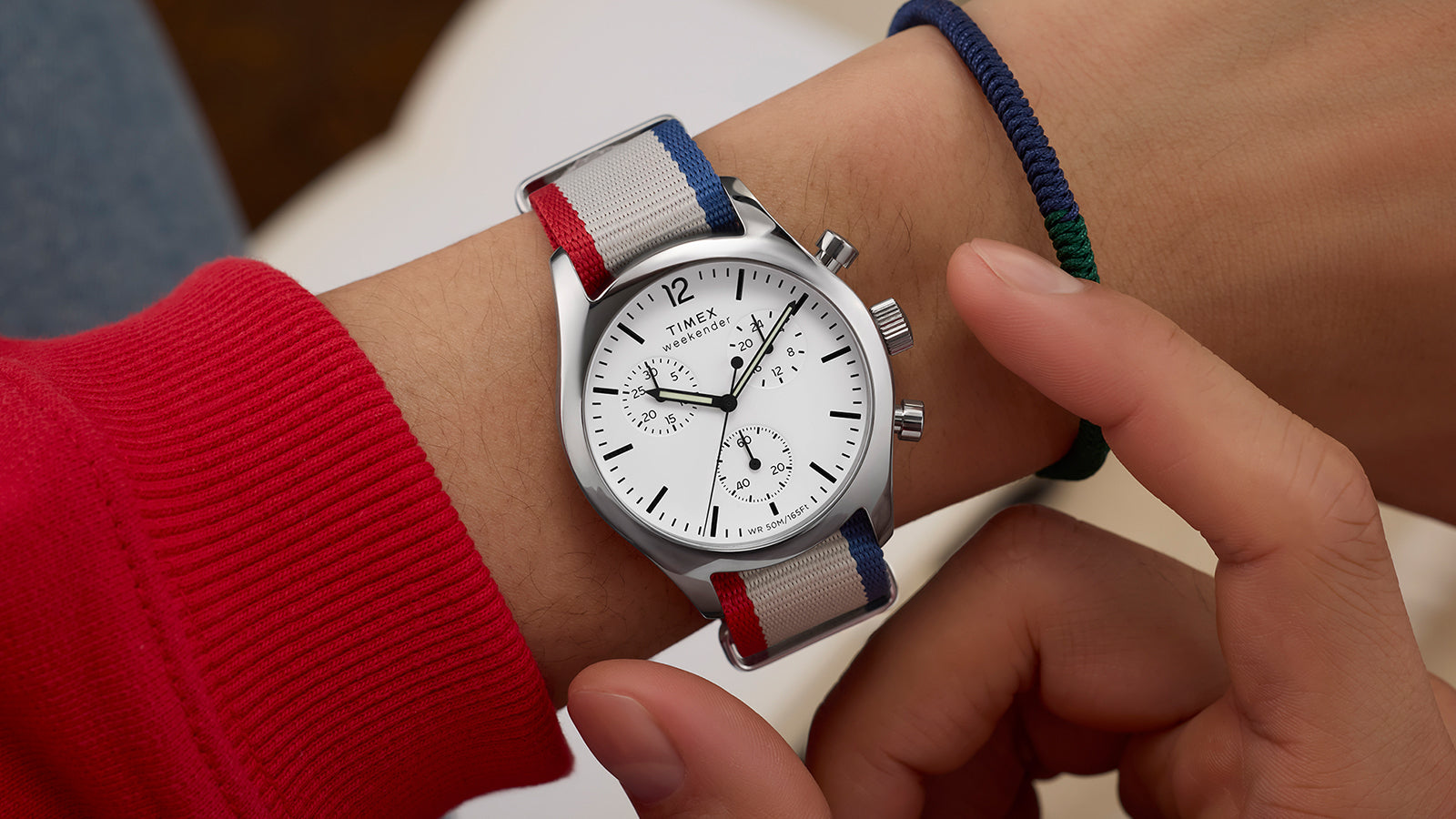 Timex Weekender New England Chronograph worn on a wrist, showing the white dial and striped red, white, and blue strap.