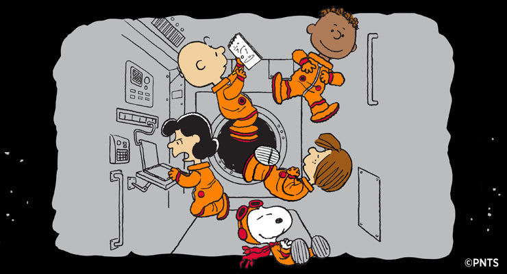 A wide banner illustration featuring Snoopy, Charlie Brown, Lucy, Franklin, and Peppermint Patty floating in zero gravity inside a gray spacecraft cabin, dressed in orange space suits, against a black starry background.