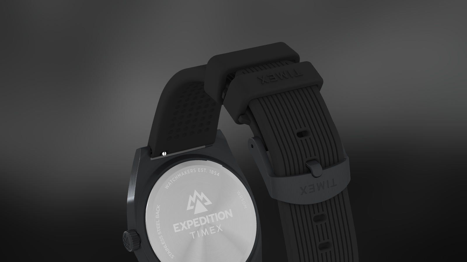 Rear and strap detail of the Timex Expedition® Capstone watch, showing the engraved stainless-steel case back with Expedition logo and the textured black silicone strap with Timex branding.