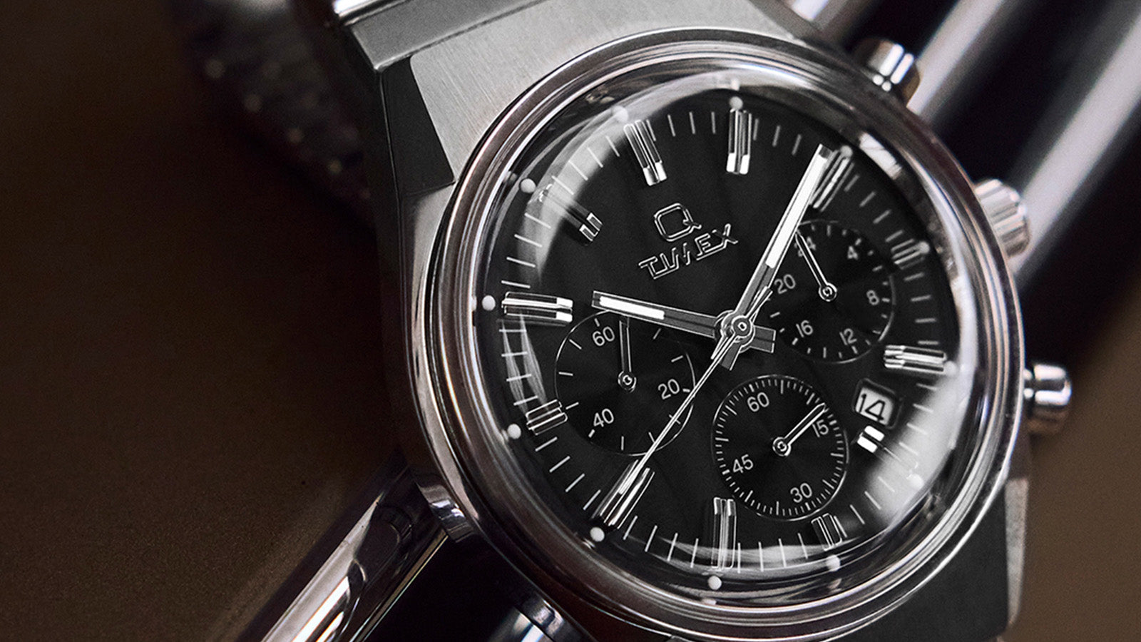 Macro shot of the Q Timex Falcon Eye Chronograph dial highlighting polished hour markers, subdials, and the embossed Q Timex logo.