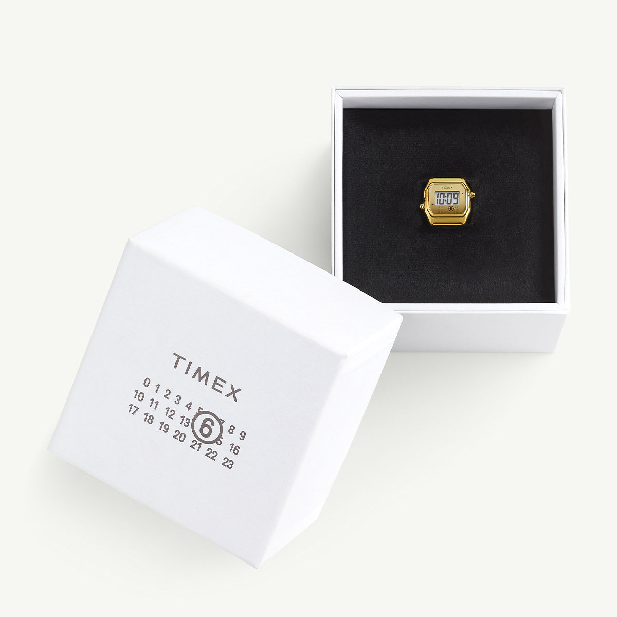 Timex x MM6 Maison Margiela T80 ring watch presented in an open white box with black velvet interior. The packaging features the MM6 calendar logo and Timex branding, emphasizing the collaboration’s sleek, luxury presentation.