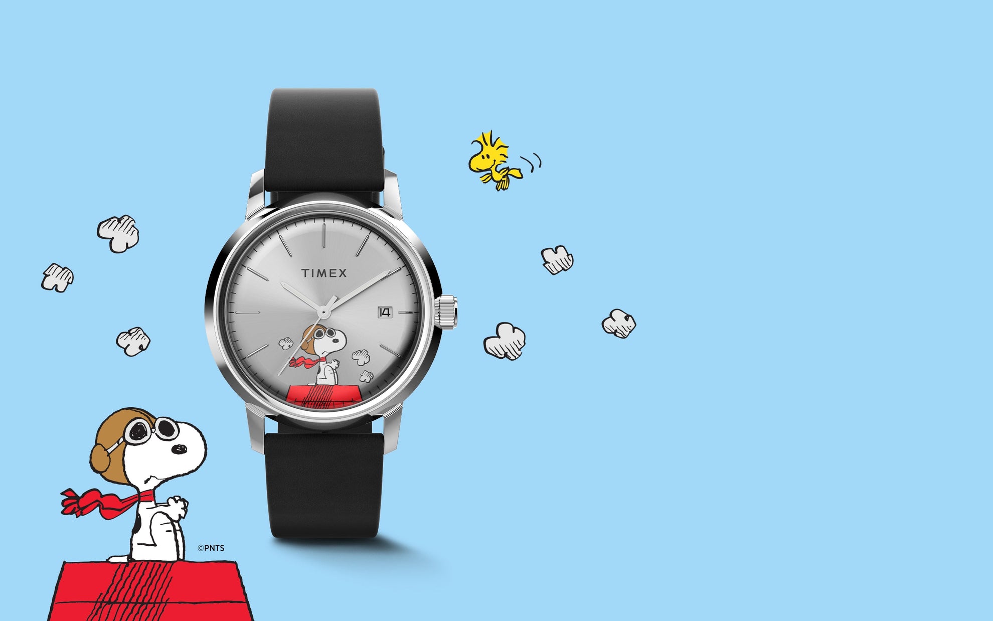 A Timex Marlin® Automatic x Peanuts Snoopy Flying Ace watch with a silver-tone dial and black leather strap displayed against a light blue background. Snoopy, dressed as a flying ace, sits on his red doghouse with clouds and Woodstock flying nearby, evoking a playful aviation theme.