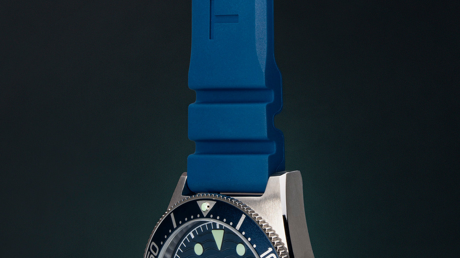Close-up of Timex Deepwater Reef 200’s upper case and blue silicone strap, showcasing the textured strap design and polished bezel finish.