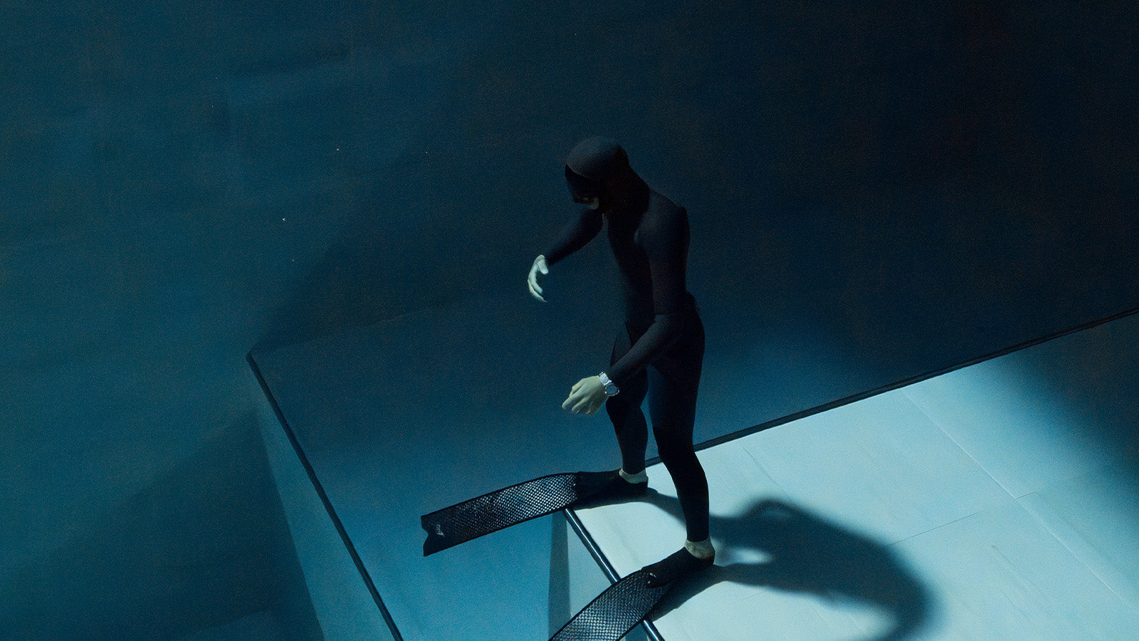 Diver underwater wearing the Timex Deepwater Reef 200 XCF, surrounded by blue tones and shadows, emphasizing the watch’s 200-meter water resistance and professional-grade durability.