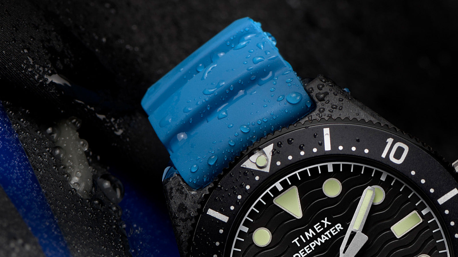 Close-up of the Timex Deepwater Reef 200 XCF blue silicone strap with water droplets, showcasing its flexible, high-performance dive-ready material.