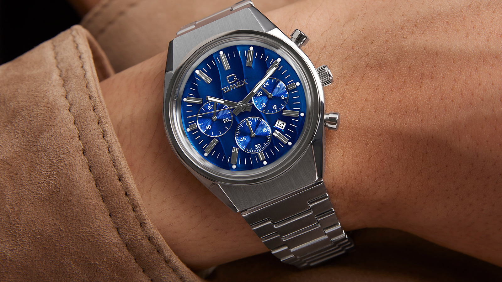 Q Timex Falcon Eye Chronograph on wrist, showing the bold blue dial with silver chronograph subdials, luminous hands, and brushed metal case paired with a stainless-steel bracelet.