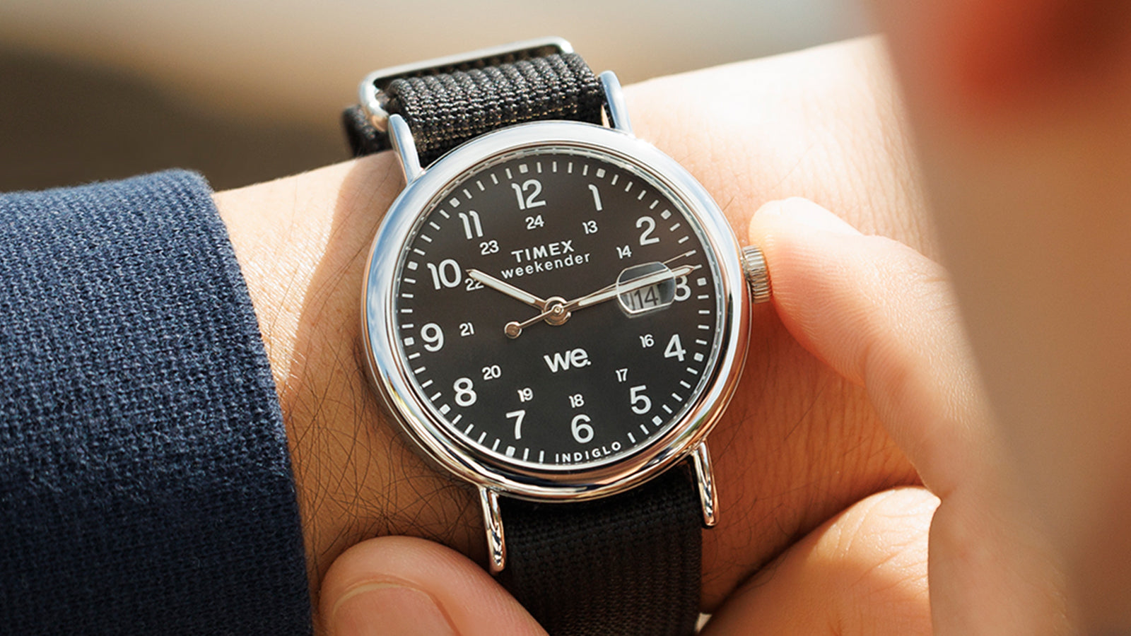 Close-up of the Timex Weekender with black dial and black strap worn on a wrist, as the wearer adjusts the crown.