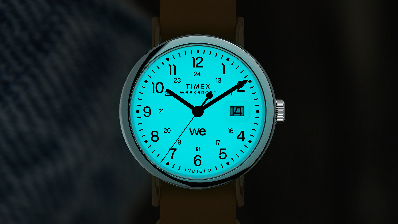 Timex Weekender glowing with blue Indiglo backlight in the dark, highlighting black numerals and date window.