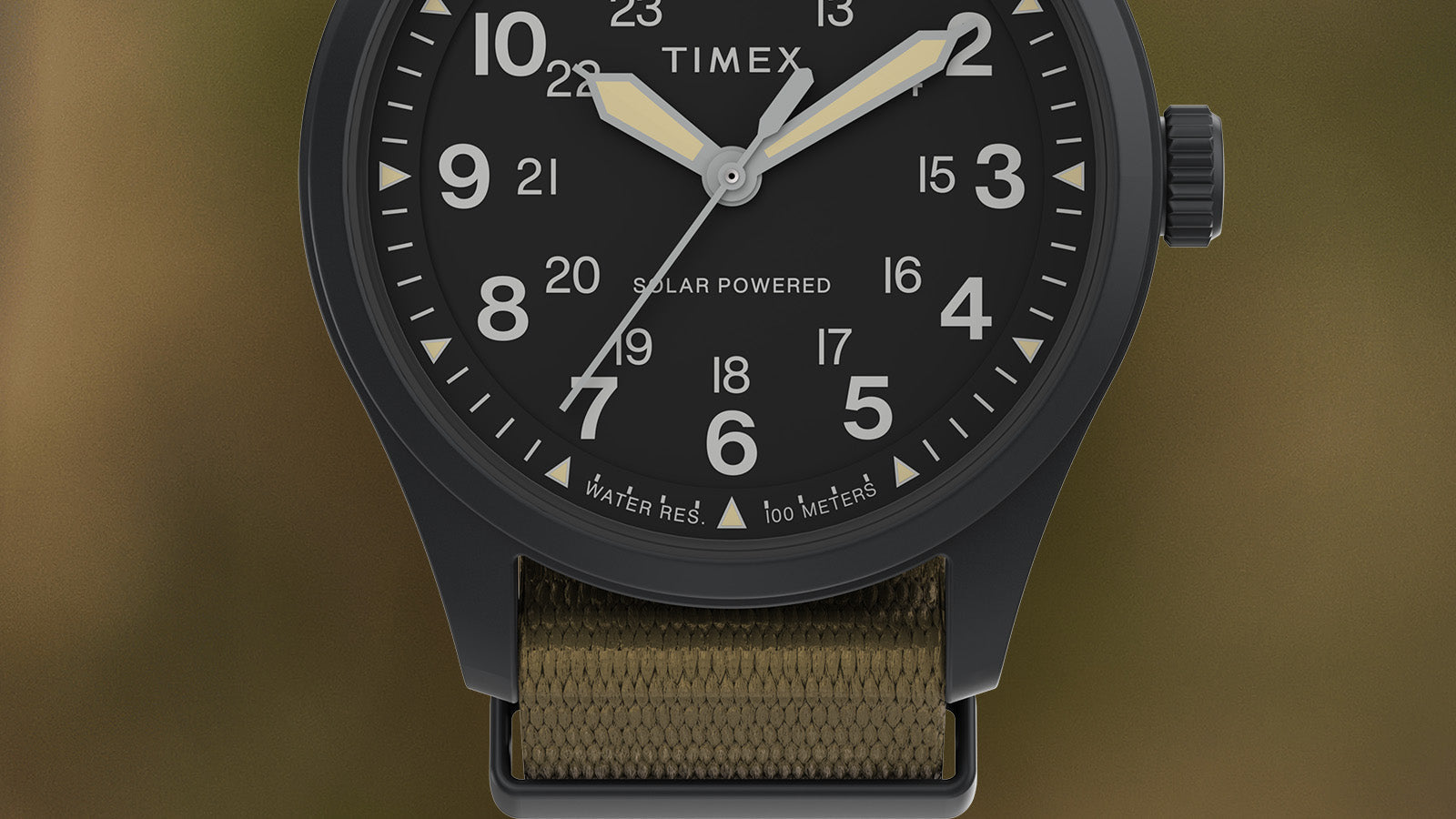 Close-up of the Timex Expedition Field Post Solar watch dial showing white 12- and 24-hour markings, luminous hands, and text reading “Solar Powered” and “Water Resistant 100 Meters.”