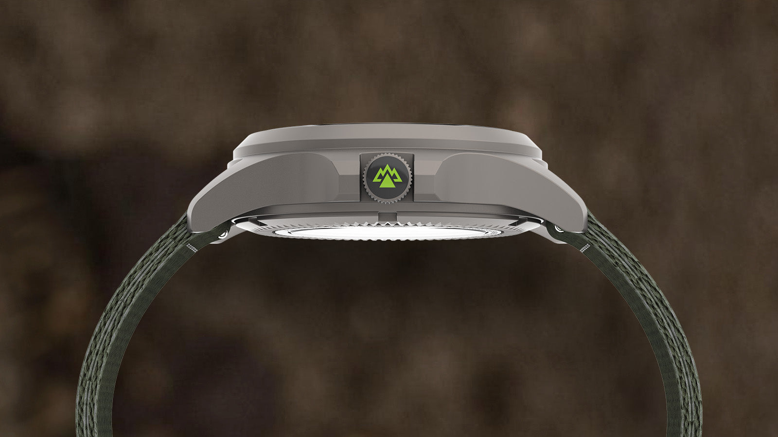 Side profile of the Timex Expedition North Titanium Automatic watch showing its matte titanium case, screw-down crown with green mountain logo, and durable green fabric strap.