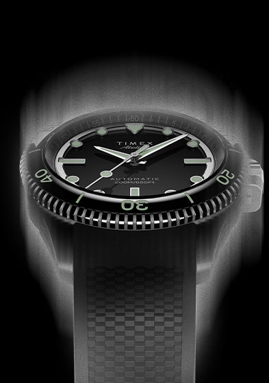 Front view of the Timex Atelier automatic dive watch with black dial, luminous indices, and black textured rubber strap, designed for mobile display.