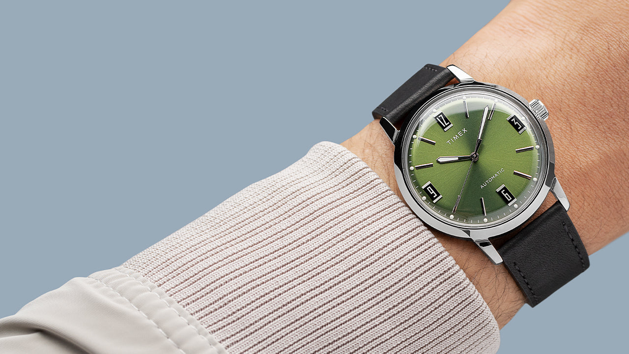 Timex Marlin Automatic worn on wrist, featuring elegant green dial, polished silver case, and black leather strap.