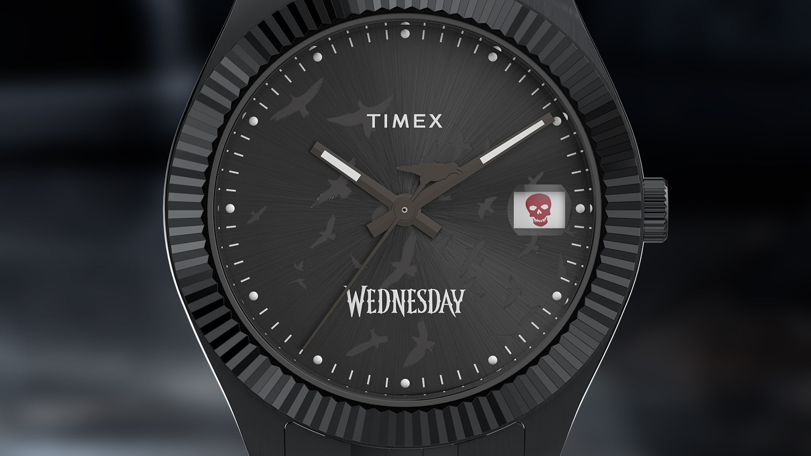 Macro view of the Timex x Wednesday Timex Legacy dial showing the engraved raven pattern, bold “Wednesday” text, and red skull date indicator. The dark radial texture enhances the watch’s gothic and mysterious style.