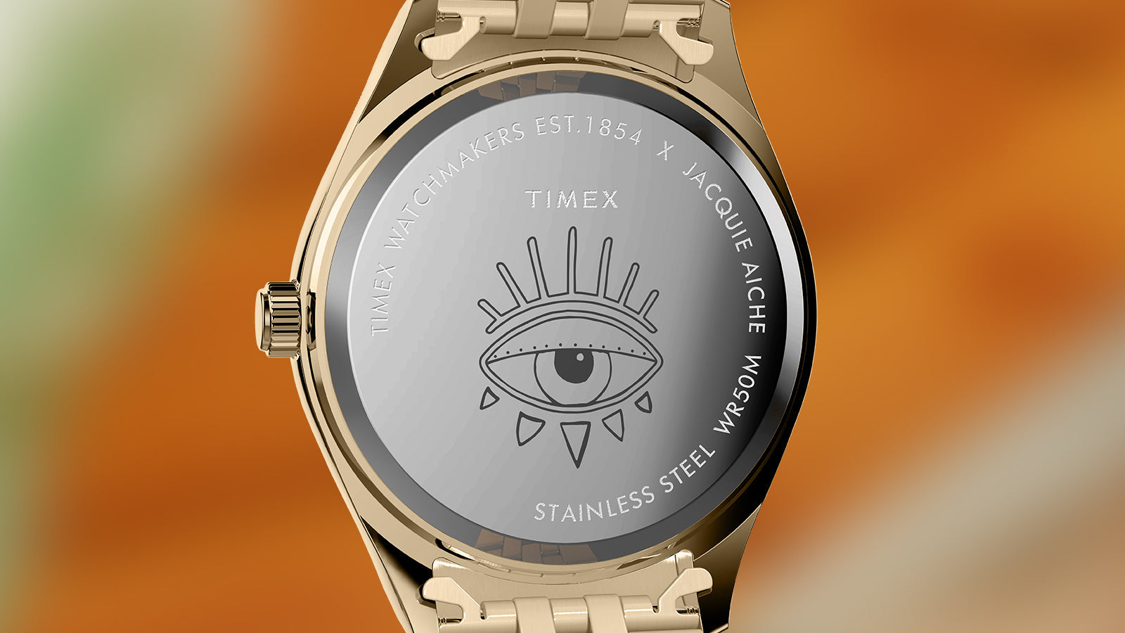 Rear view of the Timex x Jacquie Aiche “Desert Daze” watch featuring the engraved eye symbol on the stainless steel case back with co-branded markings. The gold-tone bracelet adds a luxurious finish.