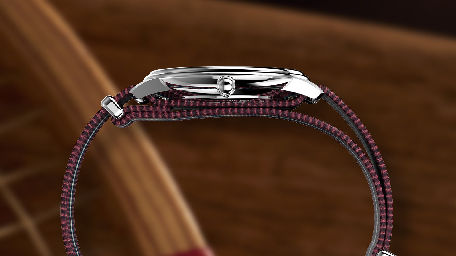 Side view of the Timex Waterbury Metropolitan Sub-Second displaying the slim stainless steel case and red-striped fabric strap.