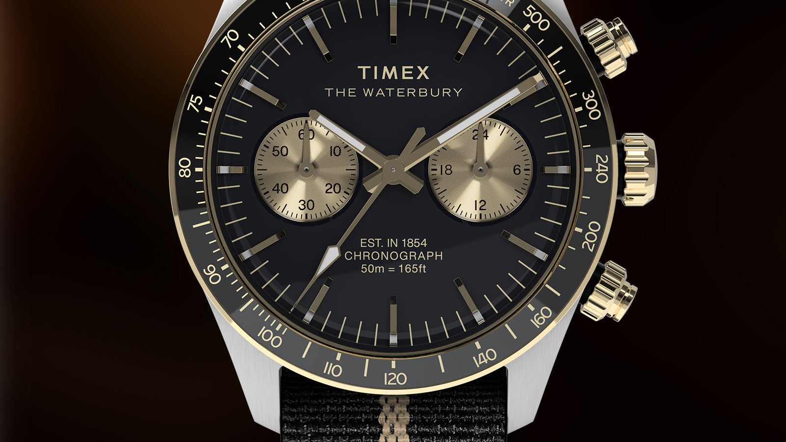 Macro close-up of the Timex Waterbury Heritage Chronograph dial featuring gold sub-dials, tachymeter bezel, and luminous hands.