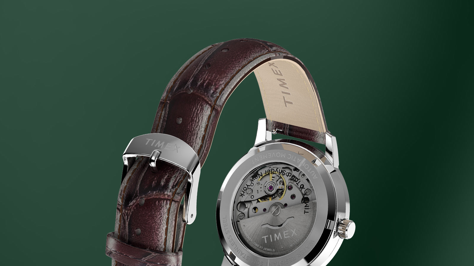 Todd Snyder x Timex Olive Marlin Automatic laid horizontally on a wooden surface, highlighting the green sunray dial and silver-tone case.