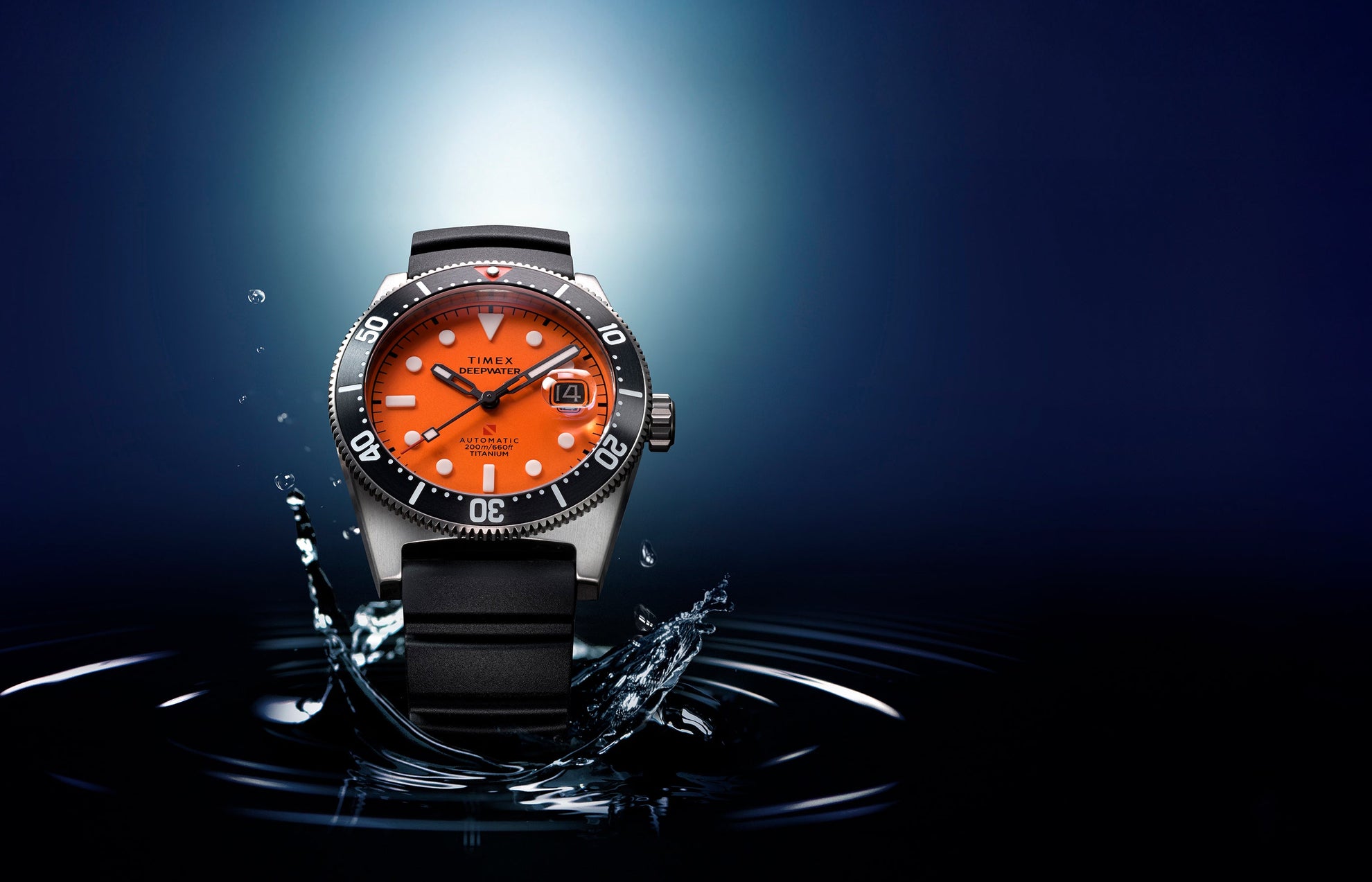 Timex Deepwater Reef 200 watch with a bright orange dial emerging from dark water, with droplets splashing around the titanium case and black dive bezel.