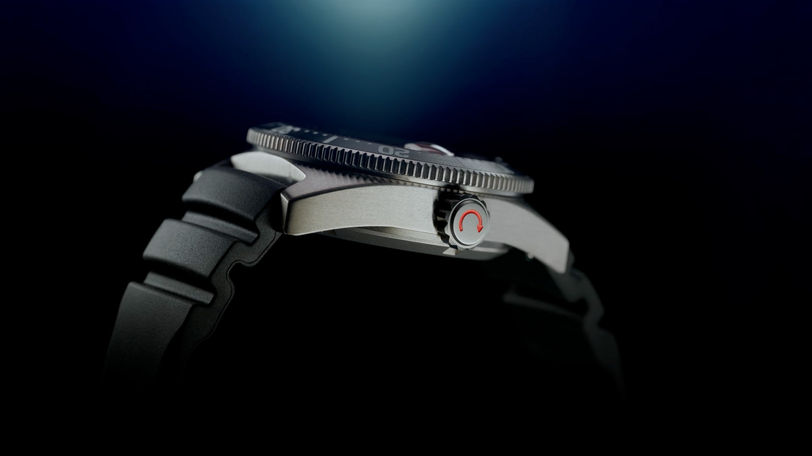 Side profile of the Timex Deepwater Reef 200 focusing on the brushed titanium case, screw-down crown with a red accent, and black rubber strap.