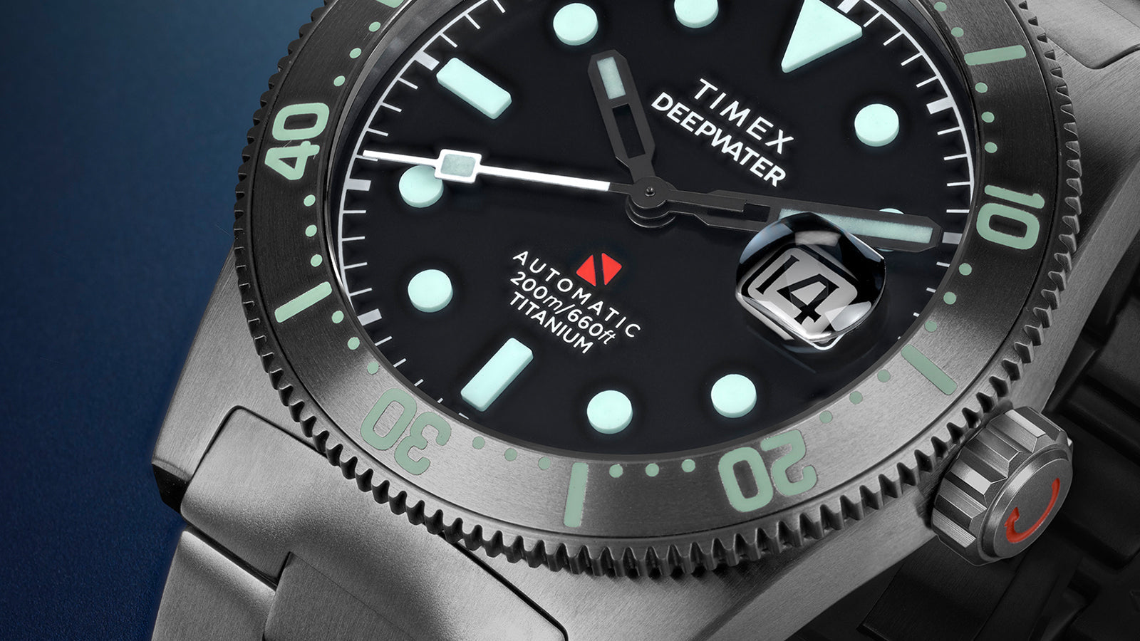 Close-up of the Timex Deepwater Reef 200 Titanium dial showing the luminescent markers, minute track, date magnifier, and engraved titanium bezel.
