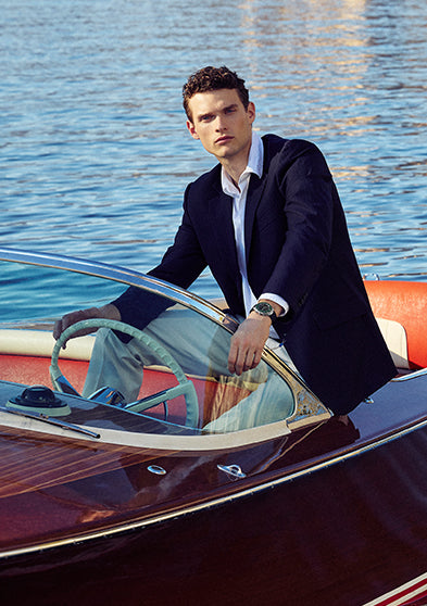 Model wearing the Q Timex® Continental Chronograph while seated in a classic speedboat on the water.