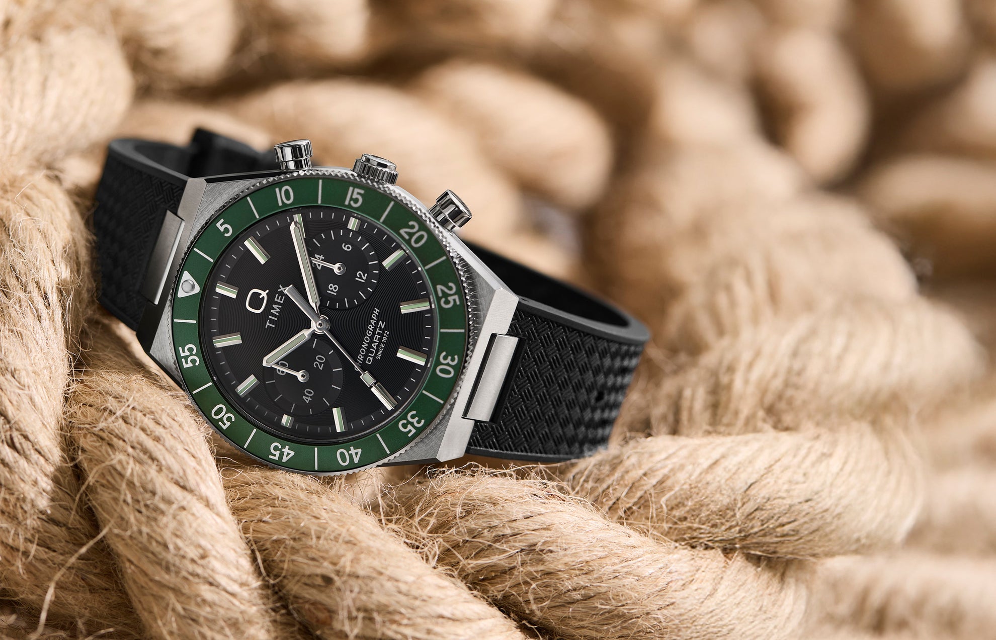 Q Timex® Continental Chronograph watch with a green bezel, black dial, and black rubber strap, styled on coiled rope.
