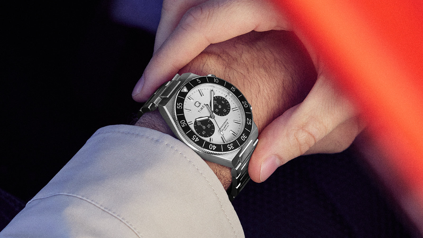 Q Timex Continental Chronograph worn on the wrist, featuring a silver dial, black bezel, and stainless steel bracelet.