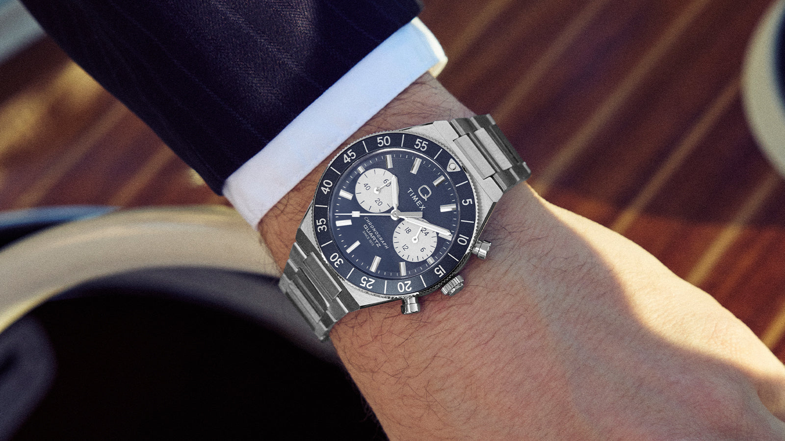 Q Timex Continental Chronograph worn on the wrist, featuring a blue dial, black bezel, and stainless steel bracelet.
