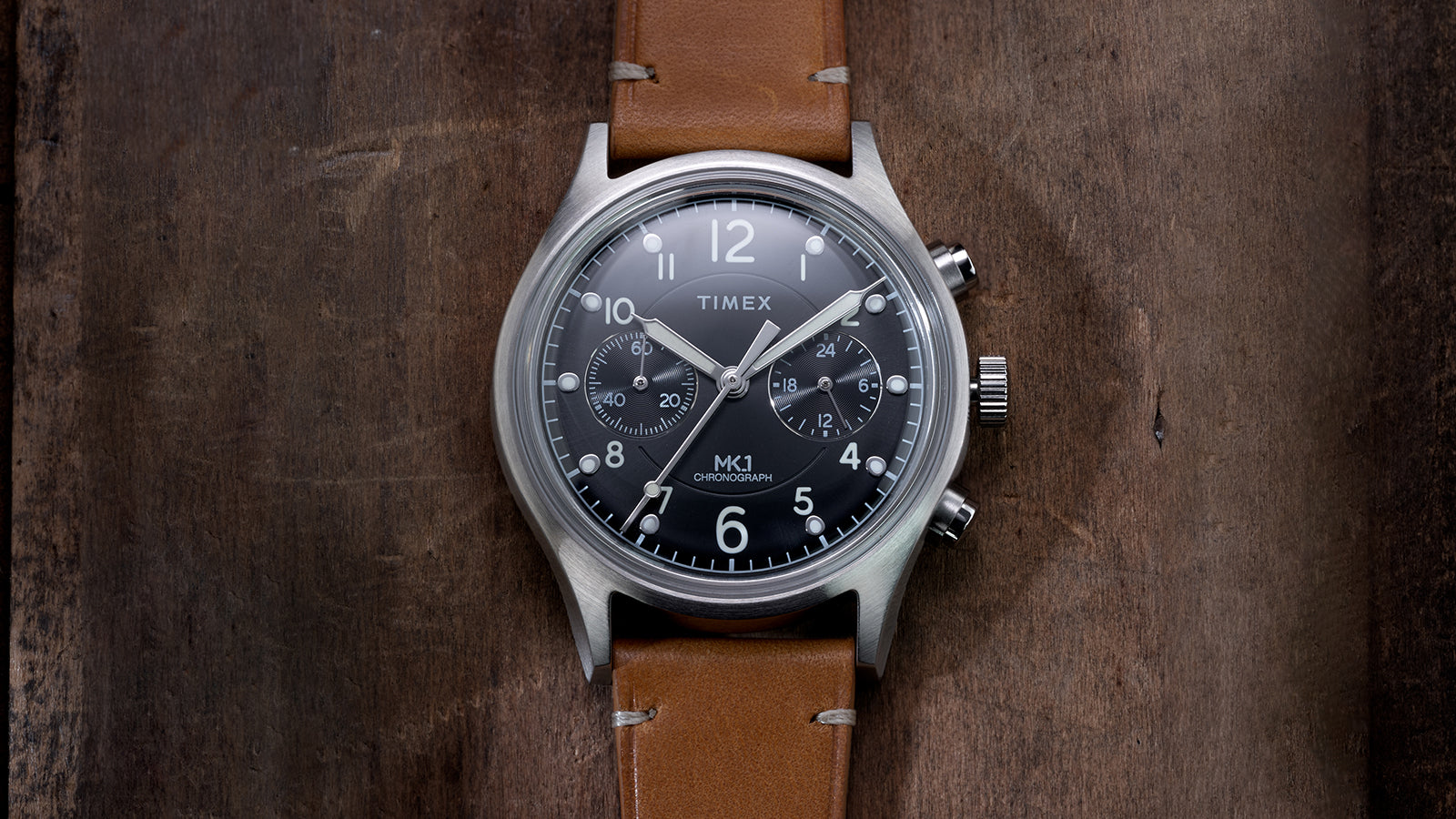 Close-up of Timex MK1 Chronograph black dial with luminous hands, Arabic numerals, and dual chronograph subdials.