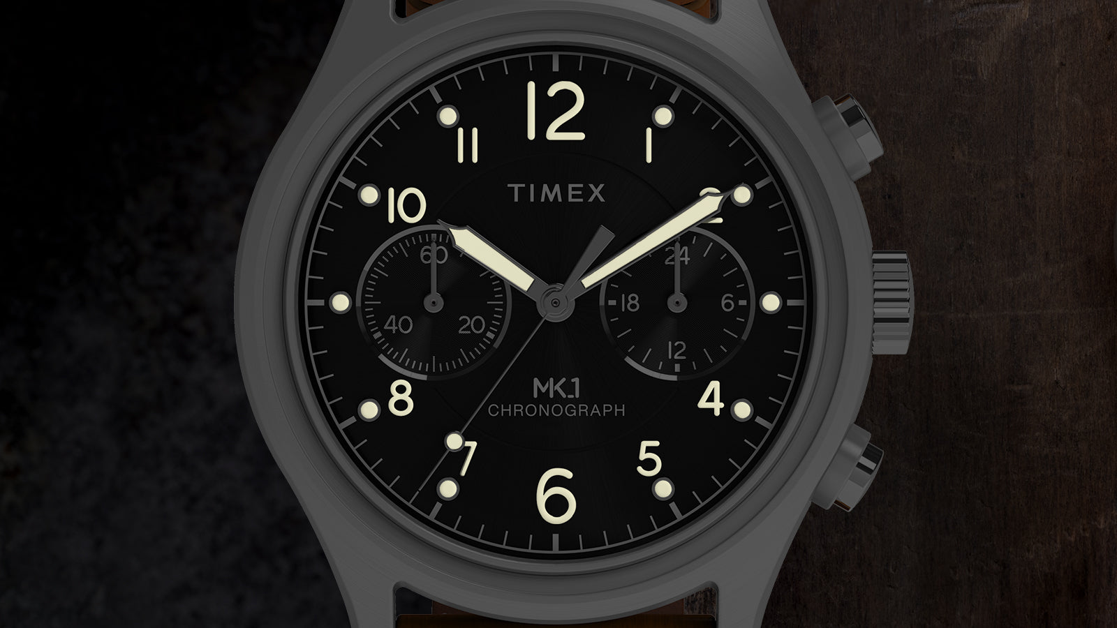 Close-up of Timex MK1 Chronograph black dial featuring luminous hands, Arabic numerals, and dual chronograph subdials.
