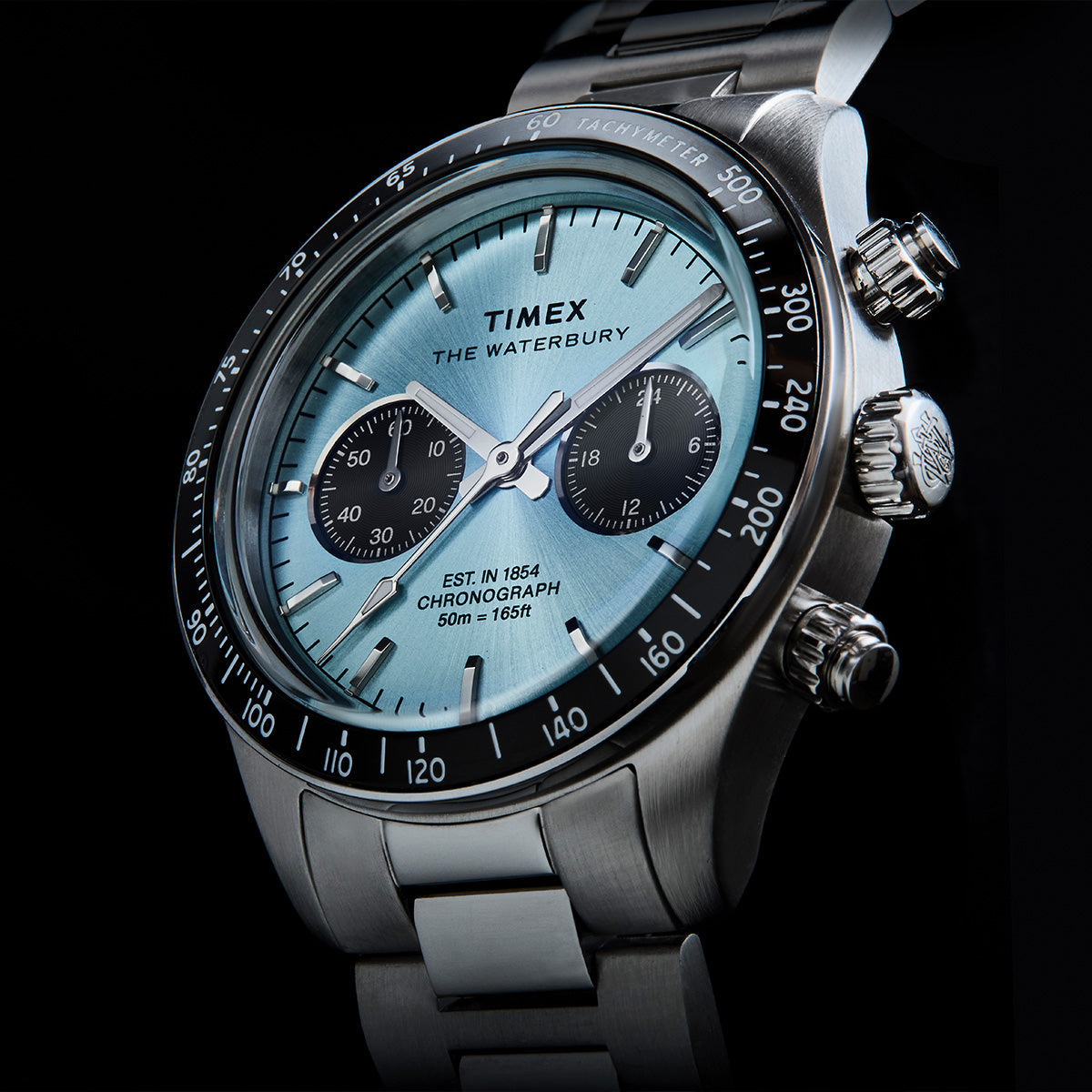 Angled close-up of Timex Waterbury Heritage Chronograph showing the light blue dial, chronograph subdials, and tachymeter bezel.