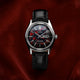 Front view of the Q Timex® Red Vega 1978 Reissue watch showing the red and black patterned dial, day-date window, and black leather strap.
