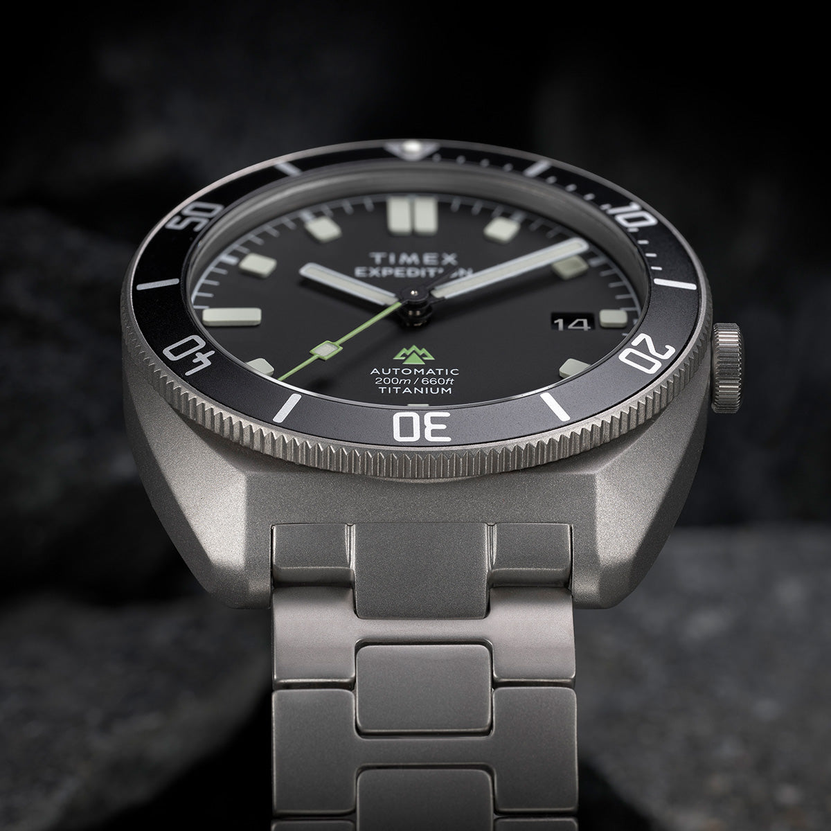 Angled close-up of the Expedition® Pioneer Titanium Automatic showcasing the matte titanium case, bold luminous markers, and “Automatic 200m/660ft Titanium” text.