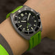 Detailed wrist shot of the Expedition® Pioneer Titanium Automatic with titanium case, date window, and green rubber strap.