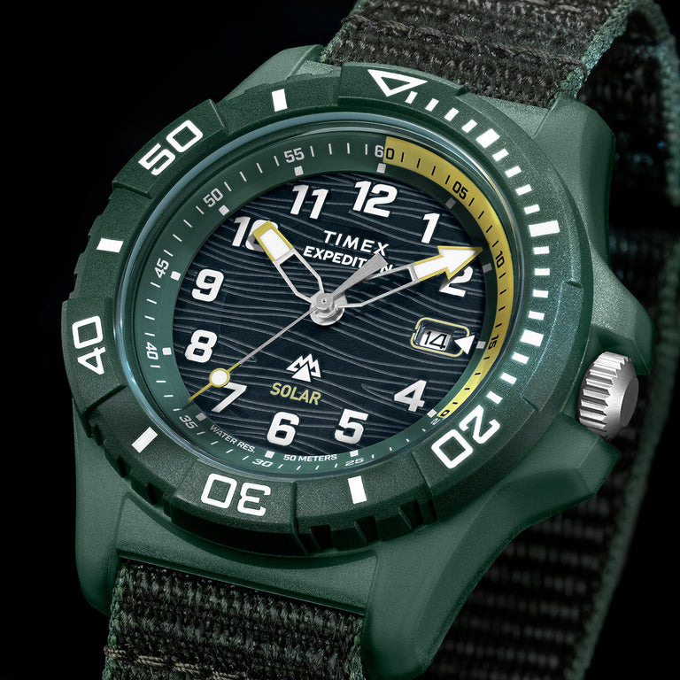 Timex Expedition® Freedive Solar watch with green resin case, black dial, yellow accents, and 50-meter water resistance on dark background.