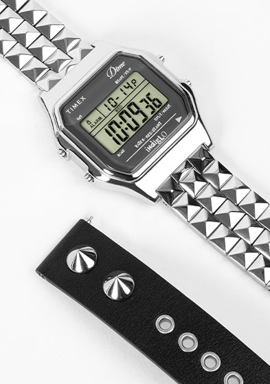 Timex x Dime digital watch with stainless steel pyramid-link bracelet and black studded leather strap on white background.