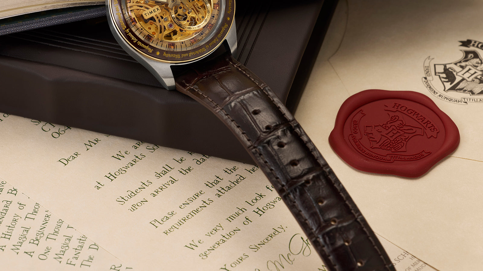 Harry Potter x Timex Waterbury Skeleton Automatic watch resting on Hogwarts acceptance letter with brown leather strap detail.