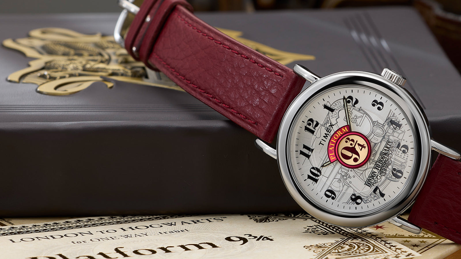Harry Potter x Timex Weekender Platform 9¾ watch with silver-tone case and red leather strap displayed on Hogwarts books and ticket.