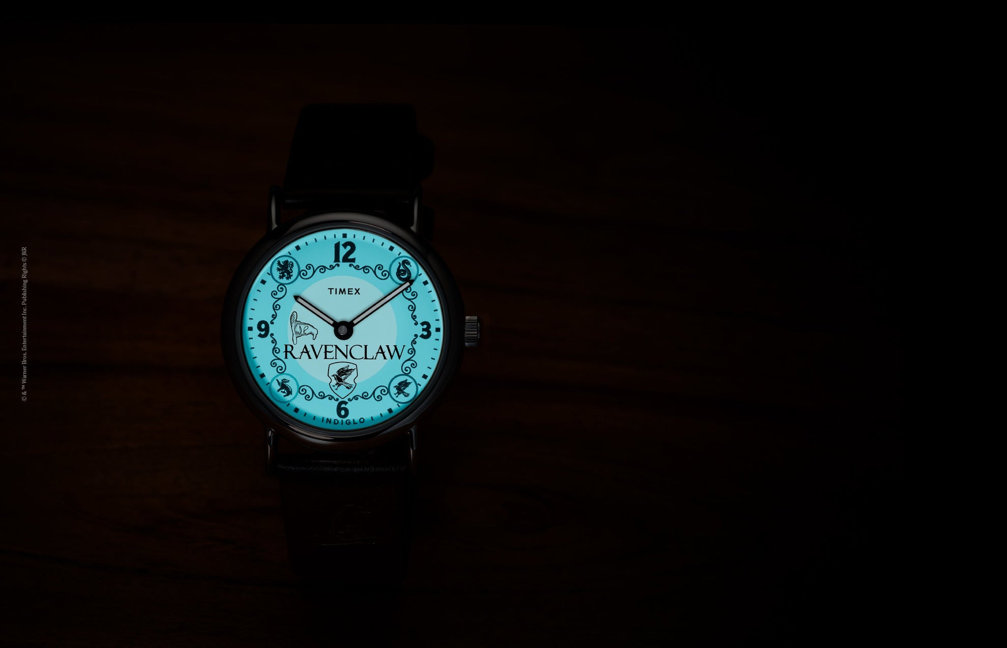 Harry Potter x Timex Weekender Ravenclaw watch illuminated in blue INDIGLO mode showing Ravenclaw name and house crest.