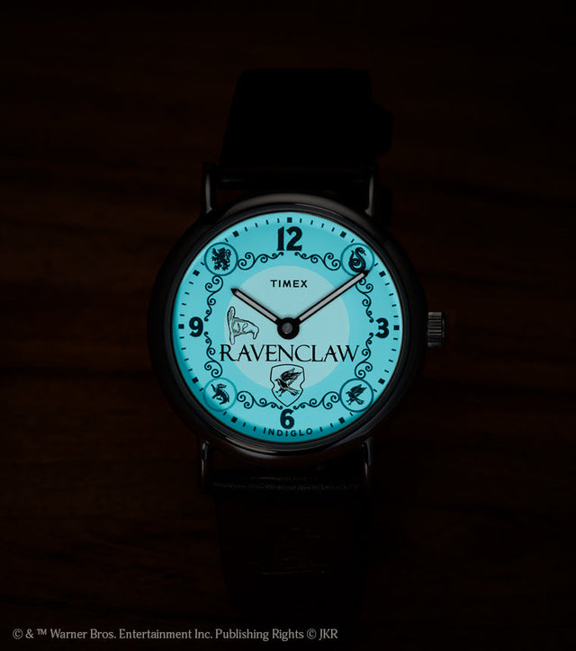 Harry Potter x Timex Weekender Ravenclaw watch illuminated in blue INDIGLO mode showing Ravenclaw name and house crest.