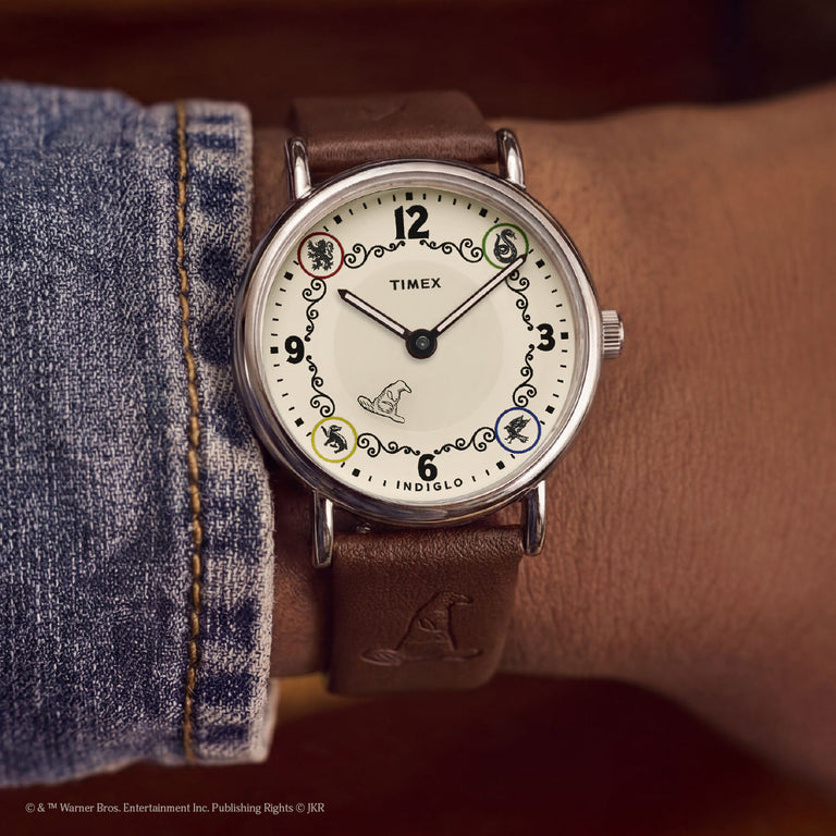 Harry Potter x Timex Weekender Gryffindor House watch worn on wrist featuring house animal icons and Sorting Hat detail.