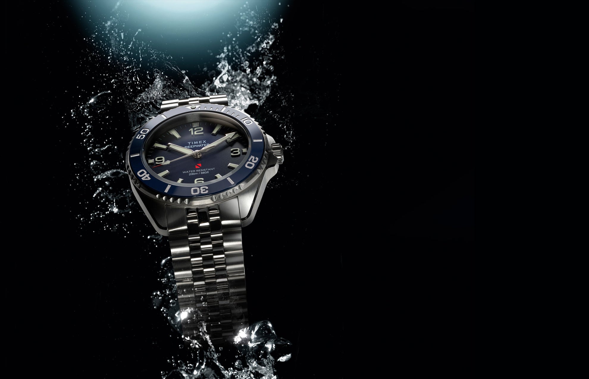 Timex Deepwater Arctic stainless steel dive watch with blue dial and rotating bezel in water splash