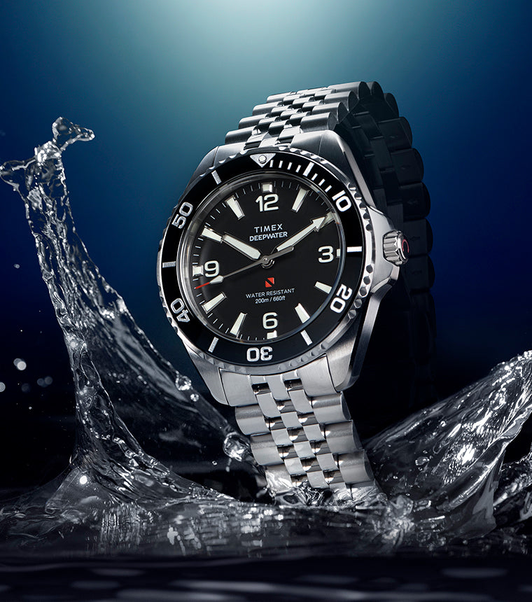 Timex Deepwater Arctic stainless steel dive watch emerging from water with black dial and rotating bezel