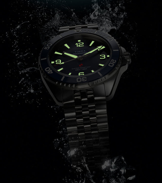 Timex Deepwater Arctic blue dial dive watch with glowing lume markers emerging through water