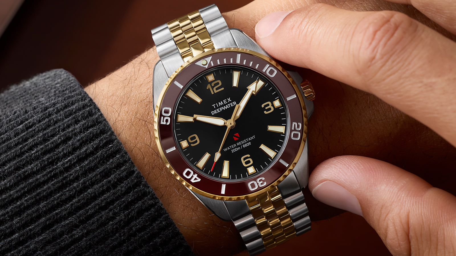 Timex Deepwater Arctic two-tone stainless steel and gold watch on wrist with burgundy bezel