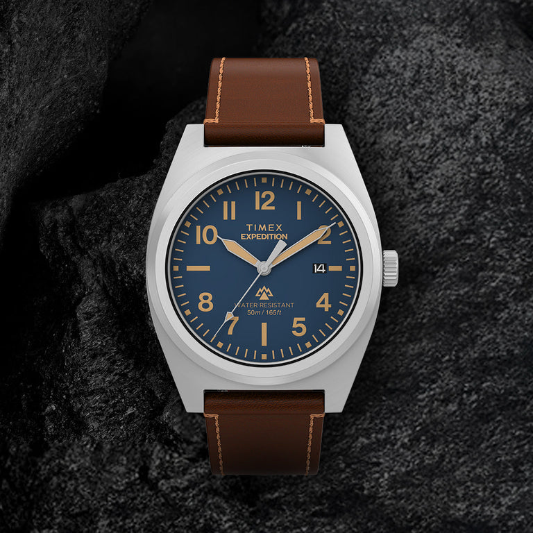 Close-up of Timex Expedition Capstone watch with blue dial, Arabic numerals, and leather strap